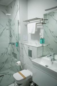 布勒伊拉Unique Garden Hotel的浴室配有卫生间、盥洗盆和淋浴。