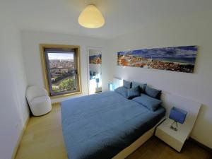 里斯本Finest Rentals - Expo Riverside的一间卧室设有蓝色的床和大窗户
