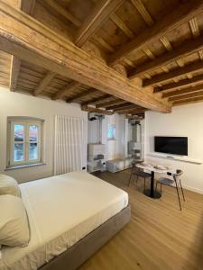 库尼奥La Dimora del Brocante的一间卧室配有一张大床和一台平面电视