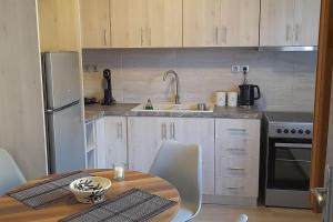 萨莫色雷斯4 Season Cozy Home的厨房配有桌子、水槽和冰箱