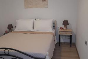 萨莫色雷斯4 Season Cozy Home的卧室配有白色的床和带两盏灯的床头柜。