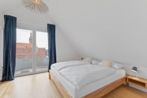 莱因费尔登-埃希特尔丁根Design-Apartment - Küche - Balkon - Tiefgarage的白色的卧室设有床和大窗户