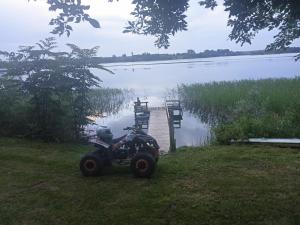 BurniszkiAgroturystyka u Basi的停在湖前的四轮车