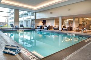哈利法克斯哈利法克斯达特茅斯希尔顿逸林酒店的酒店大堂设有大型游泳池,配有家具