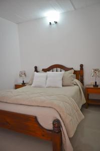 科洛尼亚-德尔萨克拉门托Apartamento Familiar Marta的一间卧室配有一张大床和两张桌子