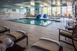月球乡匹兹堡机场希尔顿花园酒店的酒店大堂的游泳池,配有椅子