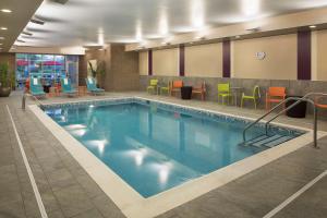 Mishawaka希尔顿米沙瓦卡南本德套房公寓的游泳池,位于酒店客房内,配有五颜六色的椅子