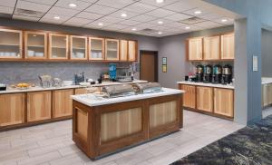 托皮卡Homewood Suites By Hilton Topeka的一个带木制橱柜和台面的大厨房