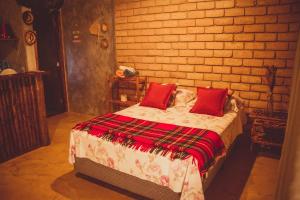 尼泰罗伊Chalé 01 Itaipu Vale da Colina Niterói的一间卧室配有一张带红色枕头的床