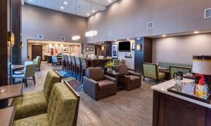 德卢斯Hampton Inn & Suites Duluth North Mn的一间带桌椅的餐厅和一间酒吧