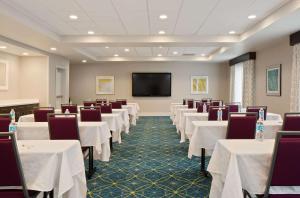 伍丁维尔汉普顿酒店及套房 - 华盛顿西雅图伍丁维尔的一间会议室,配有白色的桌椅和平面电视