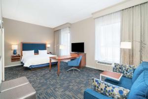 纽堡纽约纽堡斯图尔特机场汉普顿酒店的配有一张床和一张书桌的酒店客房