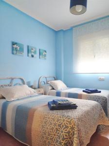 SotoserranoCasa Carla的蓝色墙壁客房的两张床