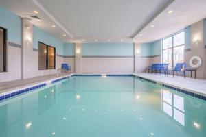 拉戈格伦登/华盛顿特区汉普顿套房酒店 的大楼内带蓝色椅子的游泳池