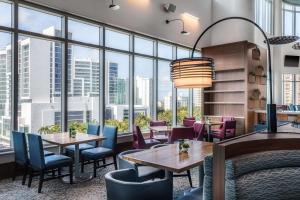 萨拉索塔Embassy Suites By Hilton Sarasota的餐厅设有桌椅和大窗户。