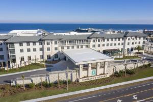 圣奥古斯丁海滩Embassy Suites St Augustine Beach Oceanfront Resort的道路一侧的白色大建筑