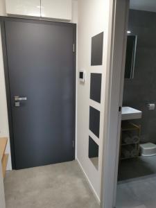 亚诺夫纳德尼索Apartmán v Jizerkách的浴室设有黑色的门和水槽。