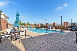 爱德蒙Hilton Garden Inn Edmond/Oklahoma City North的一个带桌椅和遮阳伞的游泳池