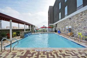 布朗斯维尔Home2 Suites by Hilton Brownsville的大楼前的游泳池