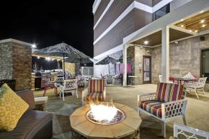 堪萨斯城KCI机场希尔顿惠庭酒店 的庭院设有火坑、椅子和桌子
