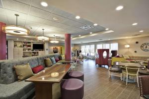 堪萨斯城KCI机场希尔顿惠庭酒店 的大堂配有沙发和桌椅