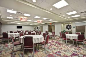 堪萨斯城KCI机场希尔顿惠庭酒店 的一间会议室,配有桌椅和屏幕