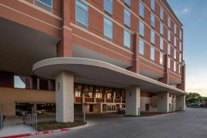 赫斯特Hilton Garden Inn Dallas At Hurst Conference Center的一座大型建筑,前面设有停车场
