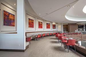 赫斯特Hilton Garden Inn Dallas At Hurst Conference Center的一间用餐室,配有红色的椅子和桌子