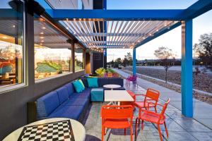 盐湖城盐湖城机场希尔顿Tru酒店的庭院设有蓝色的沙发和桌椅