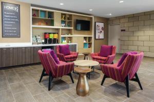路易斯威尔Home2 Suites By Hilton Louisville Airport Expo Center的一间设有紫色椅子和一张桌子的等候室