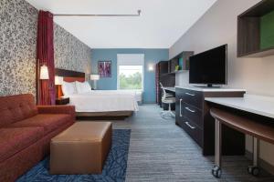 史密斯菲尔德Home2 Suites Smithfield Providence的配有一张床和一台平面电视的酒店客房