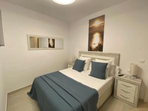 帕拉弗鲁赫尔Apartaments L’ARC的一间卧室配有一张带蓝白色枕头的大床