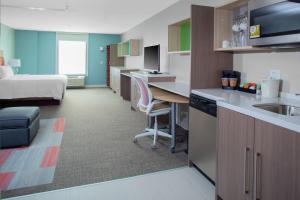 布卢明顿Home2 Suites by Hilton Bloomington的酒店客房设有厨房和卧室
