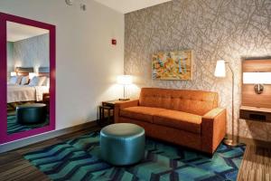 梅卡尼克斯堡Home2 Suites Mechanicsburg的酒店客房设有一张沙发和一张床