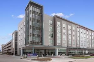 奥马哈Hilton Garden Inn Omaha Aksarben Village的一座大型办公楼,前面有标志