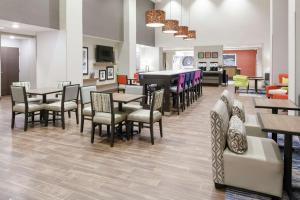 StanleyHampton Inn & Suites Overland Park South的自助餐厅内带桌椅的用餐室