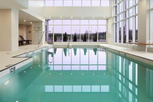 多瓦尔蒙特利尔机场希尔顿逸林酒店 的大楼内的一个蓝色海水游泳池
