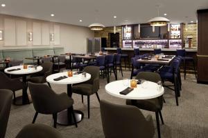 多瓦尔蒙特利尔机场希尔顿逸林酒店 的一间带桌椅的餐厅和一间酒吧