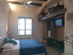 圣保罗湾城The 1930's Maltese Residence的一间卧室配有一张带吊扇和窗户的床。