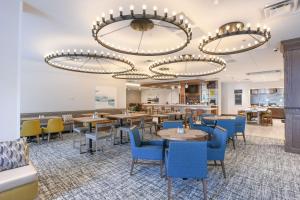 辛辛那提Hilton Garden Inn Cincinnati Midtown的一间配备有桌子和蓝色椅子的用餐室