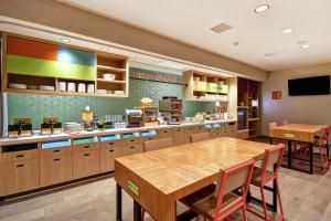 维克多维尔Home2 Suites by Hilton Victorville的一个带桌子和饭厅的大厨房