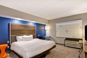 利物浦锡拉丘兹北机场区希尔顿Tru酒店的一间卧室设有一张床和蓝色的墙壁
