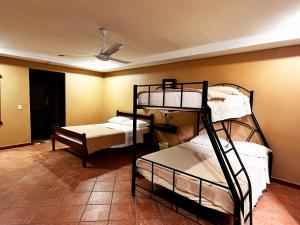 San AntonioBelen Suites的客房设有三张双层床和天花板。