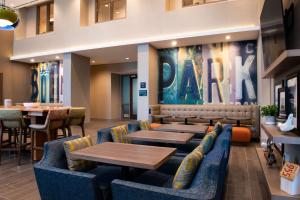 博伟公园Hampton Inn & Suites Buena Park的一间设有蓝色沙发和桌子的餐厅和一间酒吧