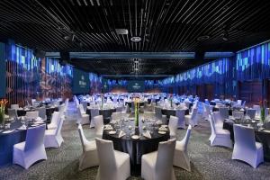莫尔兹比港Hilton Port Moresby Hotel & Residences的宴会厅配有桌子和白色椅子