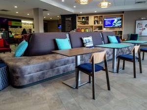 俄克拉何马城Home2 Suites By Hilton Oklahoma City Nw Expressway的商店里一张沙发,配有两张桌子和椅子