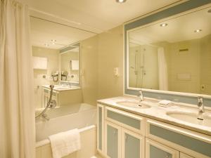 若特阿赫-埃根瓦特斯霍夫海景酒店的浴室设有2个水槽、浴缸和镜子