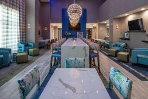 普莱诺Hampton Inn & Suites Dallas/Plano Central的一间带长桌和椅子的用餐室