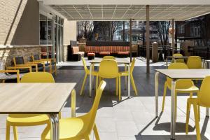 亚特兰大Home2 Suites by Hilton Atlanta Midtown的餐厅设有黄色的桌子和黄色的椅子