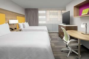 亚特兰大Home2 Suites by Hilton Atlanta Midtown的酒店客房配有两张床和一张书桌